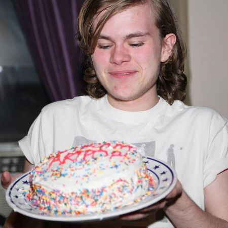 He is holding a cake in this picture